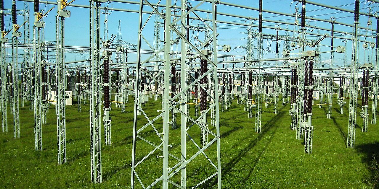 A high-voltage switchyard: rows of insulators and bus bars on steel frames.